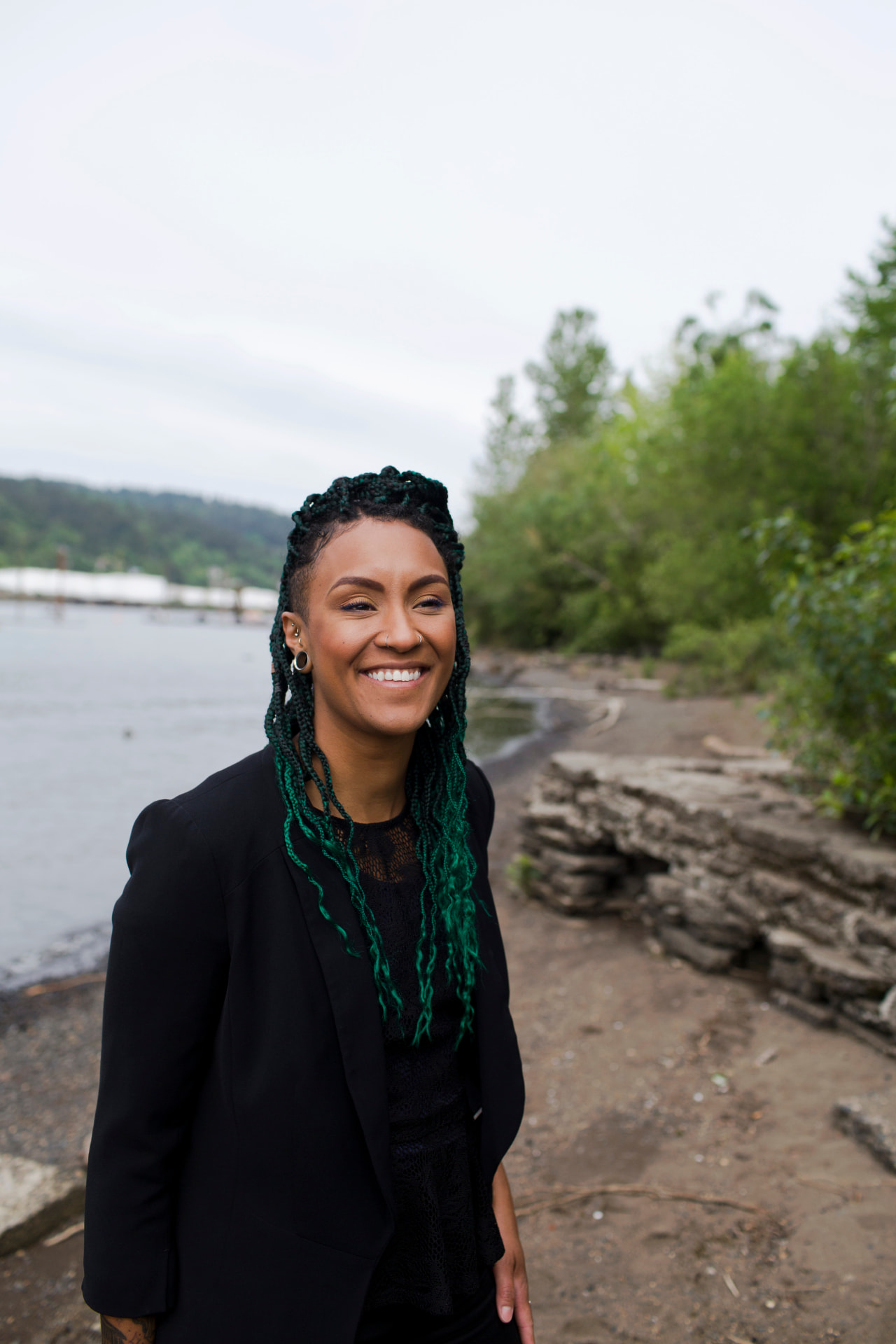 Jae Evans, founder of Quest Surrogacy, smiling outdoors by the river